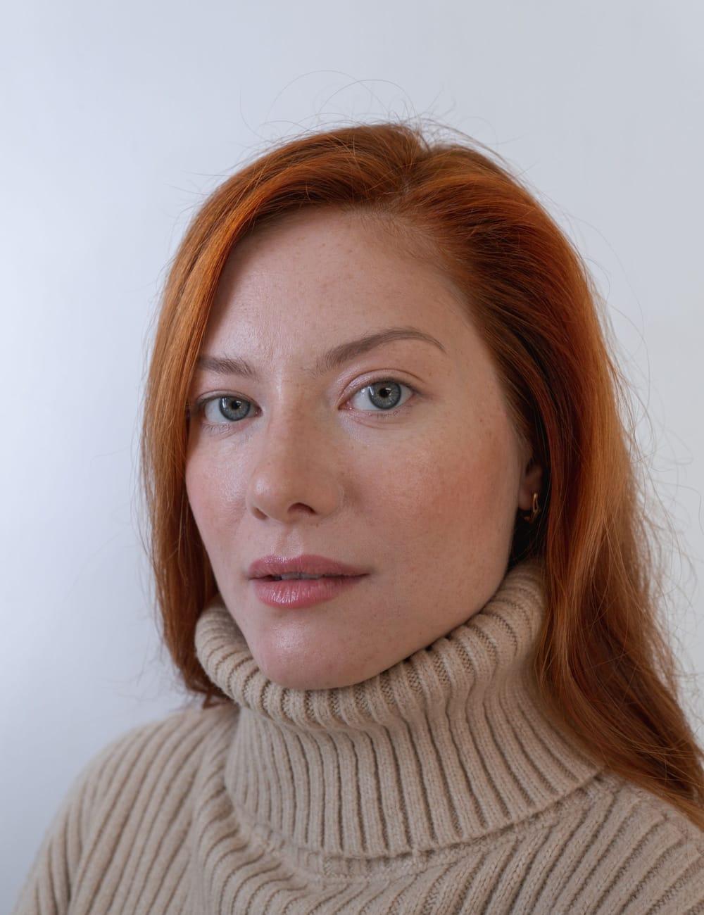 Natural portrait of a red-haired woman in a knit turtleneck